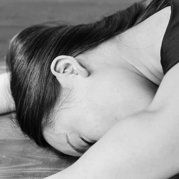 A person maintaining a difficult balance yoga pose on a mat.